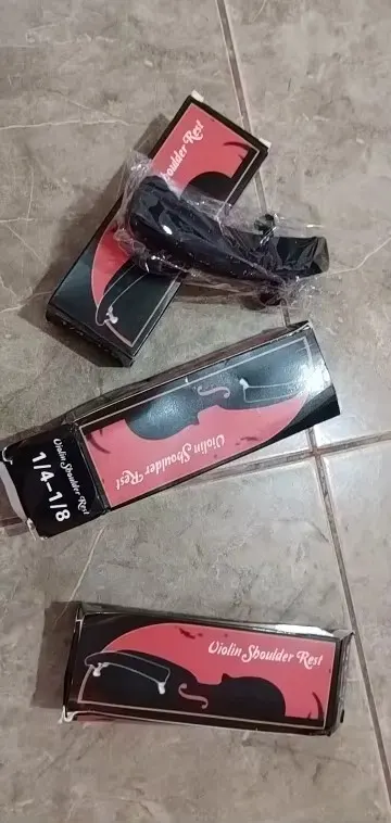 Unboxing photo of several Violin Shoulder Rest boxes with one black rest in plastic wrap, one box end labelled 1/4-1/8, submitted by a verified buyer