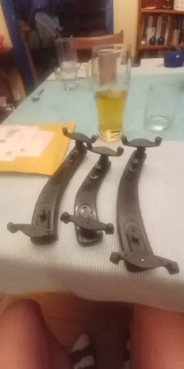 Three all-black shoulder rests laid on a table with the underside and foldable feet visible, submitted by a verified buyer